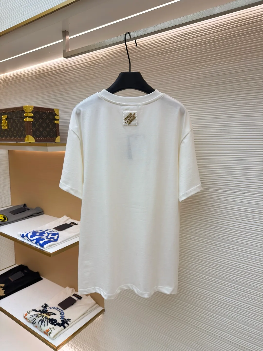 LOUIS VUITTON cotton round neck embroidered Vuitton signature logo short sleeves ●Original version: purchased and developed for 12300 ●Item number: 1682272-A10 ●Fabric: cotton fabric ●Technology: embroidery production ●Color: white ●Version: fitted version ●Weight: about 270 grams ●Size: S-M-L-XL ●Description: This white short-sleeved T-shirt is made of high-count combed cotton fabric and has been treated with pre-washing technology. It has a soft and skin-friendly touch and is not easy to deform. The silhouette of the shirt is a loose shoulder design, which meets the needs of modern casual wear. The core decoration area on the chest uses hand-beading and bronzing technology, and uses metallic gold sequins and embroidery threads intertwined to outline a three-dimensional letter pattern. The sequins are layered and inlaid, and each one is manually positioned and fixed by craftsmen to ensure a regular texture and uniform gloss. The edges of the letters are sewn with matte silk thread to form a visual contrast between gold and matte, while reinforcing the decorative structure to avoid falling off during wear. The neckline uses double-needle hemming technology and is matched with ribbed cuffs of the same fabric. It is durable and fits the neck. The overall craftsmanship combines handicraftsmanship with modern clothing technology, and the details show exquisite texture. The overall wiring is straight and delicate, the fabric is comfortable and soft, and the color is consistent without color difference. It can be matched with the same style to create a fashionable look and control various occasions. Customized accessories, complete with three standards, same style for men and women!